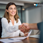 women in a business meeting shaking someones hand.