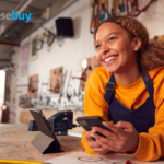 Shop owner smiling holding her phone