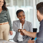 Two people shaking hands in a business meeting.